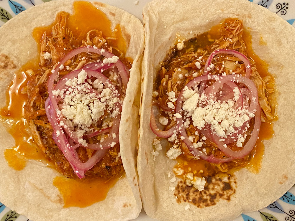 The finished tacos with pickled red onions and cotija cheese