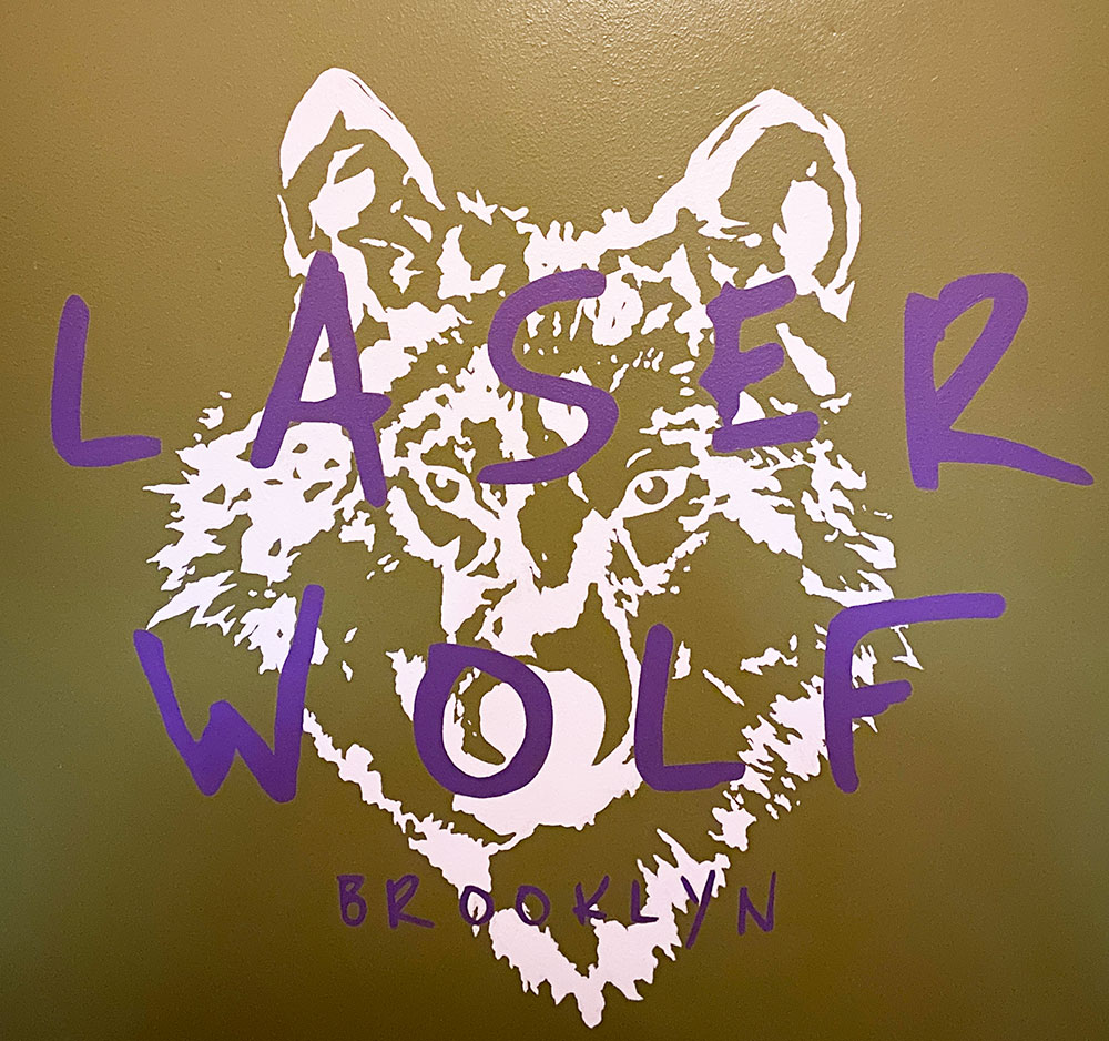the sign for Laser Wolf restaurant outside the elevators at the entrance