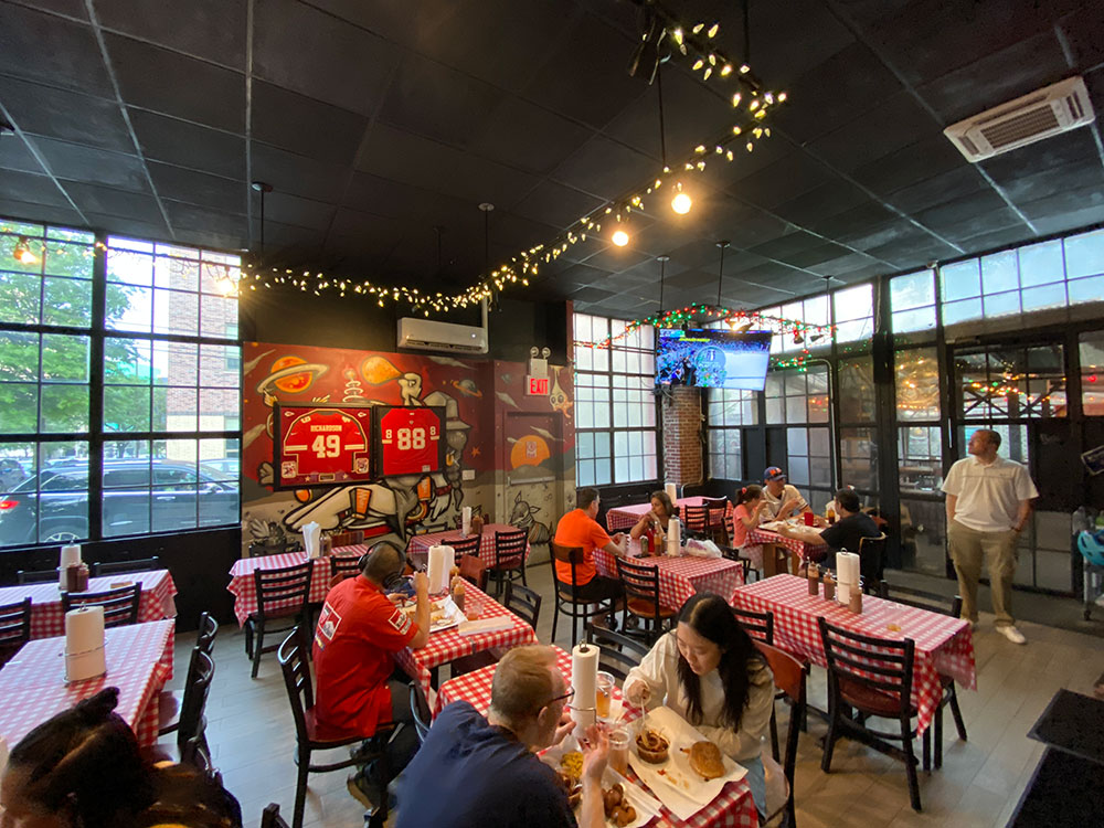 Indoors at John Brown's is covered with Kansas City sports memorabilia. The casual space has televisions, Christmas lights, and tables topped with red checked table cloths.