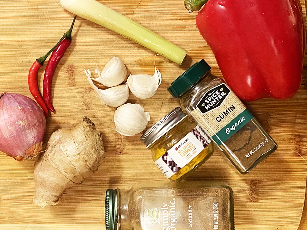 Ingredients for curry paste include ginger, garlic, lemon grass, shallot, chilis, red bell pepper, cumin, turmeric, coriander