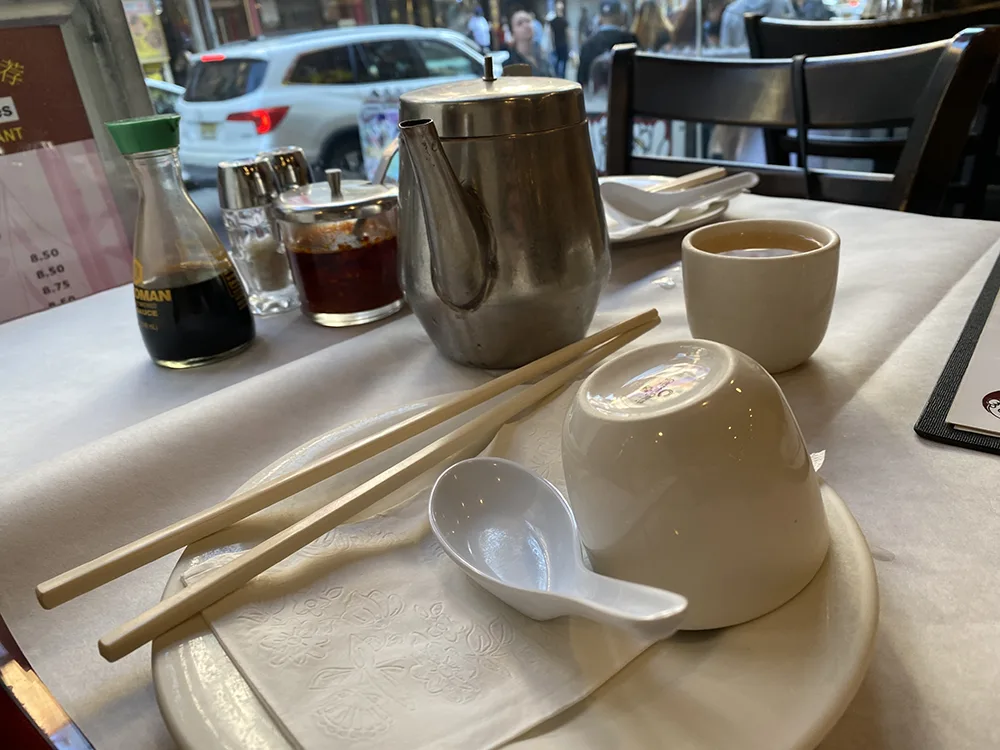 Tea, plates, utensils, soy sauce, chili crisp at the table of 456 Shanghai