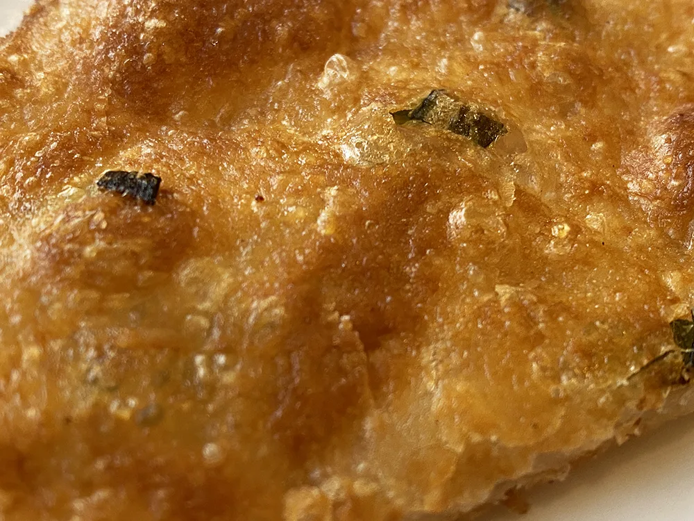 The crispy exterior of a scallion pancake