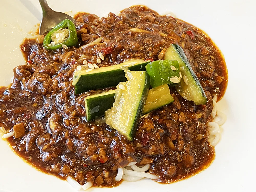 Minced pork in brown sauce over noodles