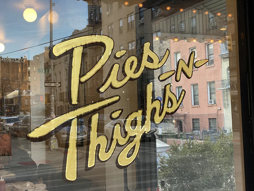 Pies -n- Thighs sign painted on the window out front