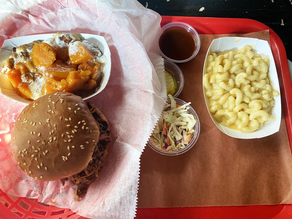 pulled pork sandwich comes with pickles and slaw and sauce